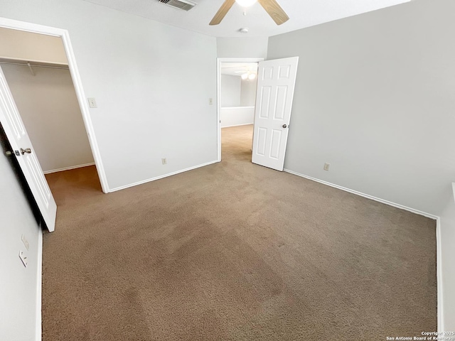 unfurnished bedroom with visible vents, carpet floors, a closet, and a spacious closet