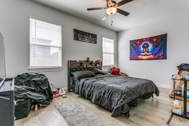 bedroom featuring wood finished floors, baseboards, and ceiling fan