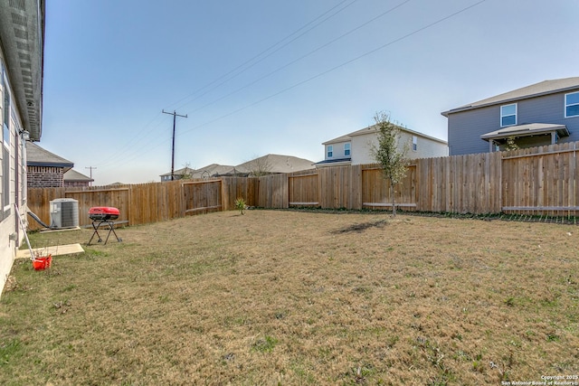 view of yard featuring a fenced backyard and central AC