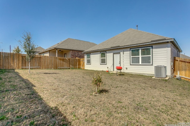 rear view of house with a yard, cooling unit, and a fenced backyard