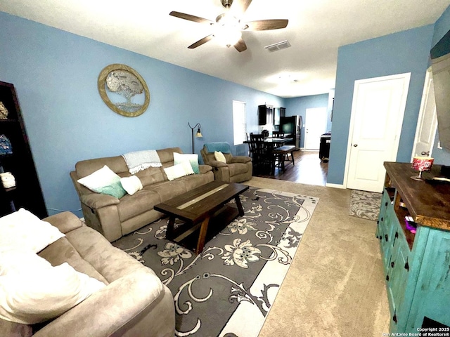 living room with visible vents, carpet, and a ceiling fan