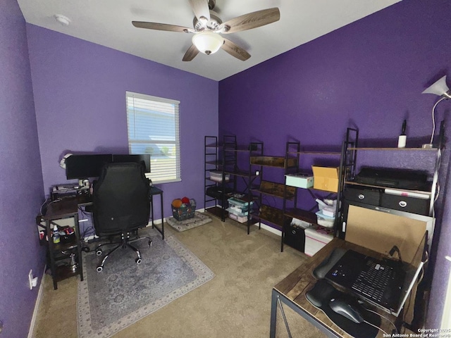 carpeted office featuring baseboards and a ceiling fan