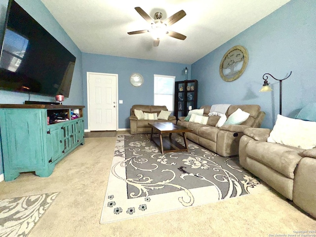 carpeted living area featuring vaulted ceiling, baseboards, and ceiling fan