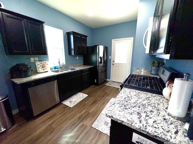 kitchen featuring light countertops, dark wood-style floors, appliances with stainless steel finishes, and a sink