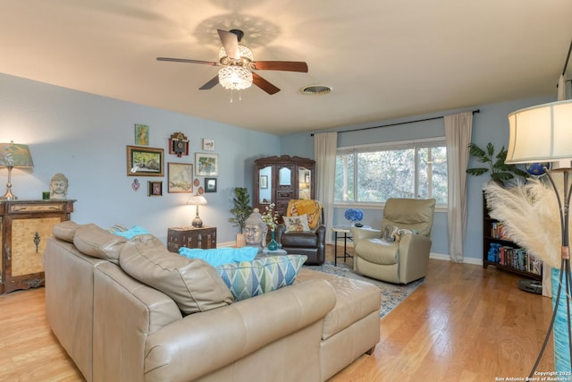 living area with baseboards, visible vents, a ceiling fan, and light wood-style floors