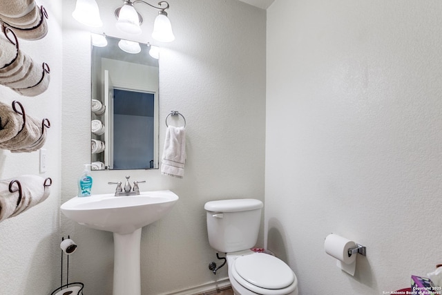 bathroom featuring toilet and baseboards