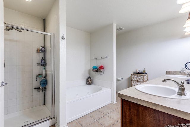 bathroom with tile patterned flooring, a stall shower, a jetted tub, and a sink