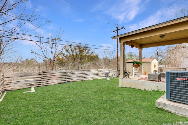 view of yard with an outbuilding, central air condition unit, a patio area, and a fenced backyard