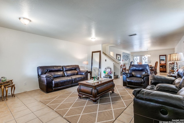 living room featuring light tile patterned floors, visible vents, and a chandelier