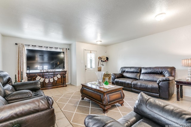 living area with light tile patterned floors, a textured ceiling, and baseboards