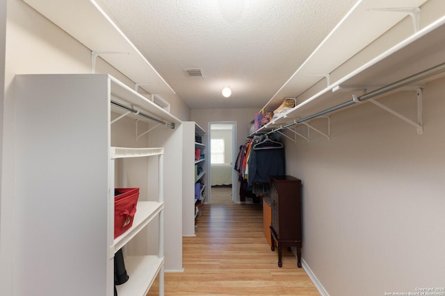 spacious closet with light wood-style flooring and visible vents