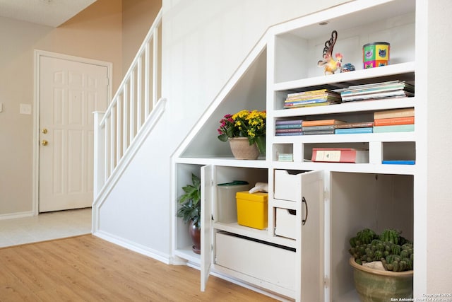 stairway with baseboards and wood finished floors