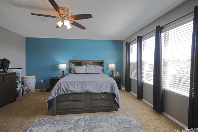 bedroom featuring a ceiling fan, baseboards, carpet floors, and a textured ceiling