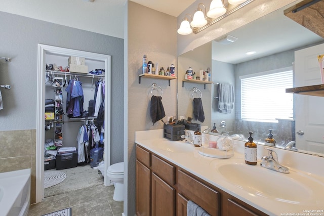 full bath featuring a sink, a garden tub, toilet, and double vanity