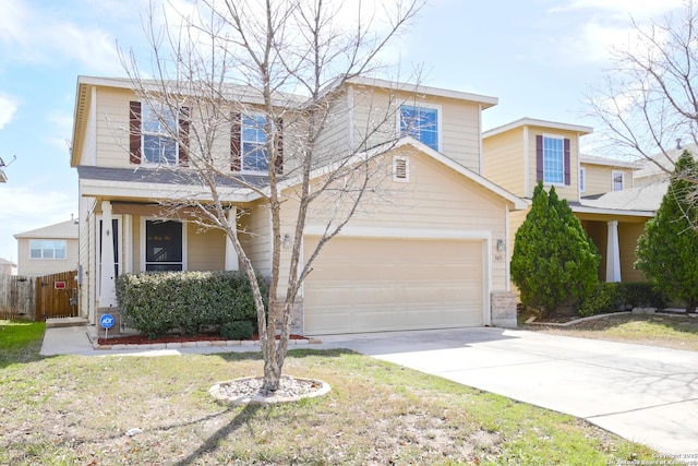 traditional home with driveway, an attached garage, and fence