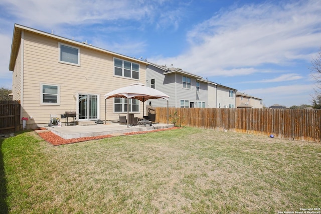 rear view of house with a patio, a lawn, and a fenced backyard