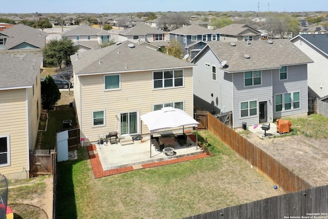 back of property with a fenced backyard, a residential view, and a patio