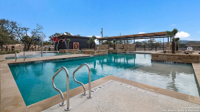 community pool with a patio area, fence, and an outdoor structure