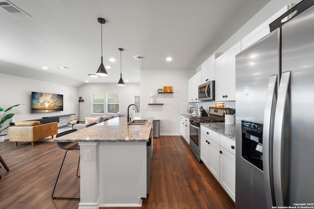 kitchen featuring visible vents, a sink, open floor plan, dark wood finished floors, and stainless steel appliances