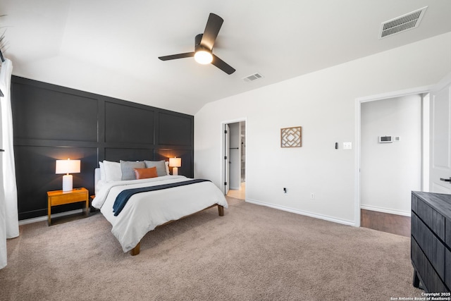 carpeted bedroom with vaulted ceiling, a ceiling fan, visible vents, and baseboards