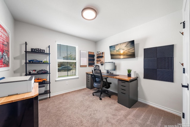 office area featuring baseboards and light carpet