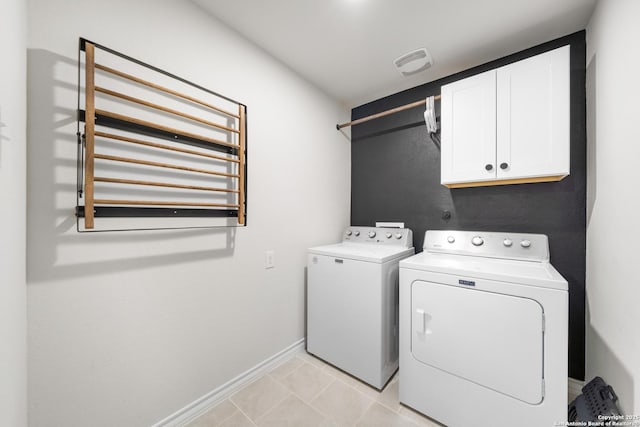 laundry room featuring visible vents, cabinet space, light tile patterned floors, baseboards, and washing machine and clothes dryer