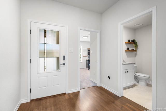 entryway with visible vents, baseboards, and wood finished floors