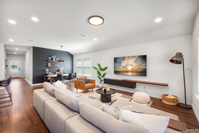 living area featuring visible vents, wood finished floors, recessed lighting, baseboards, and vaulted ceiling