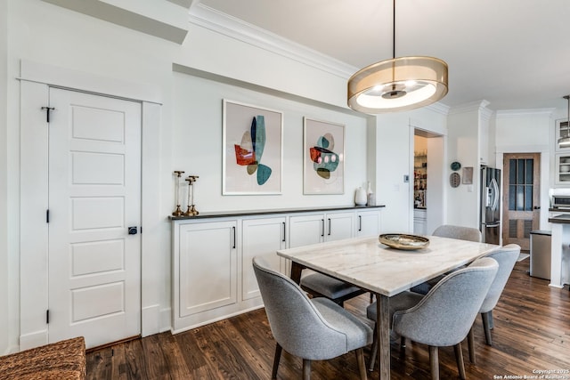 dining space with dark wood finished floors and crown molding