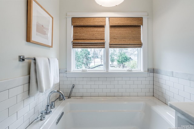 full bath with a garden tub and tile walls