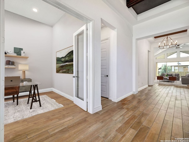 office area with wood finished floors, baseboards, an inviting chandelier, a high ceiling, and recessed lighting