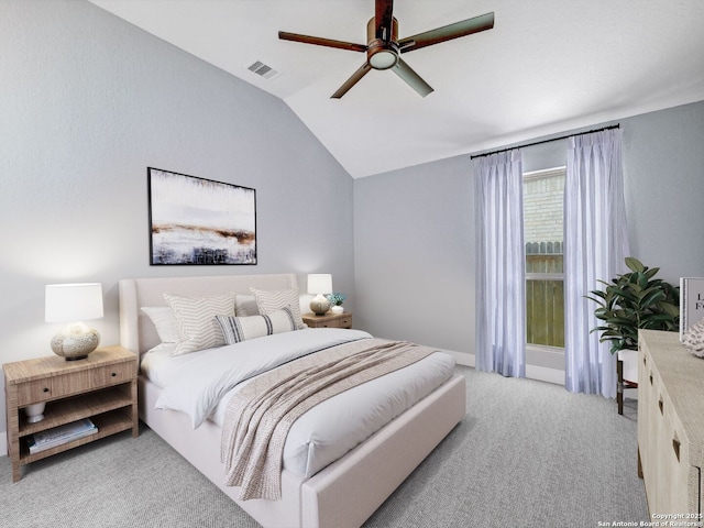 bedroom featuring visible vents, light colored carpet, ceiling fan, and vaulted ceiling