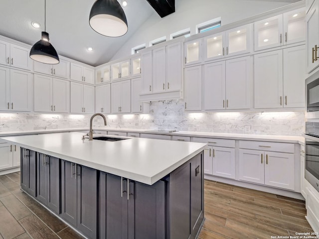 kitchen featuring a sink, lofted ceiling with beams, white cabinets, and light countertops