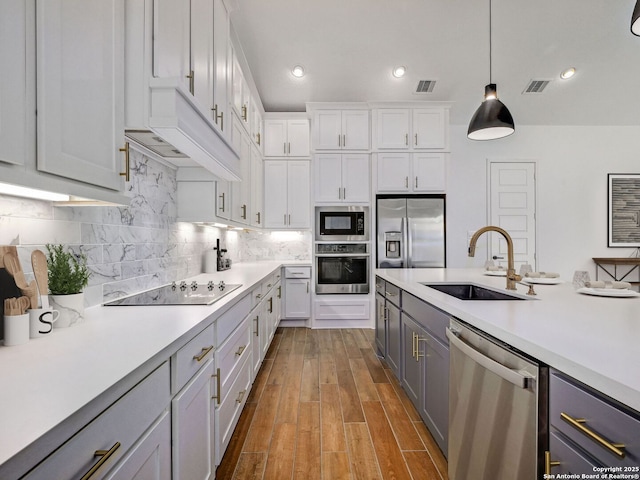 kitchen featuring visible vents, a sink, light countertops, appliances with stainless steel finishes, and tasteful backsplash