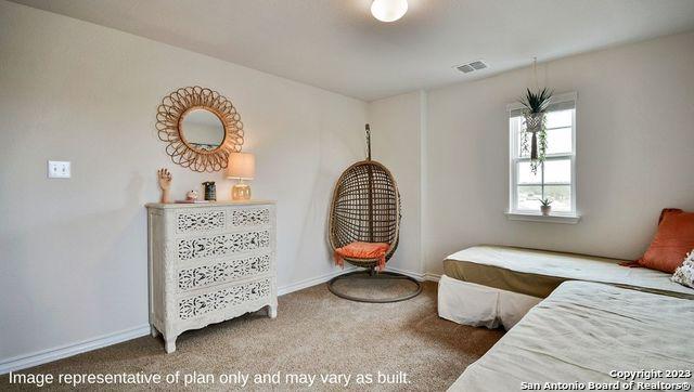 carpeted bedroom with visible vents and baseboards