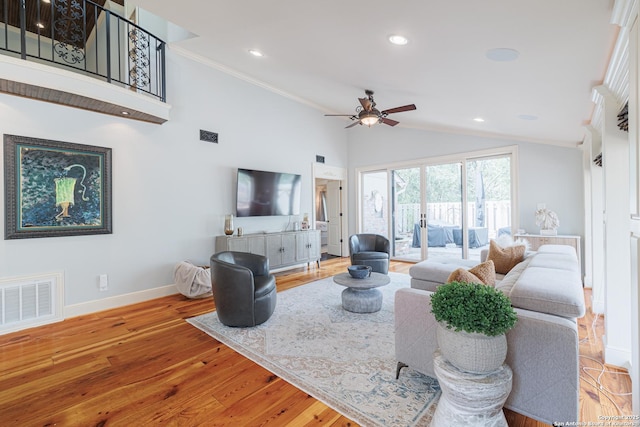 living area featuring visible vents, wood finished floors, baseboards, and ornamental molding