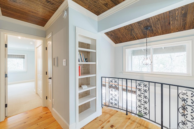 hallway featuring built in features, wood ceiling, ornamental molding, hardwood / wood-style flooring, and a notable chandelier