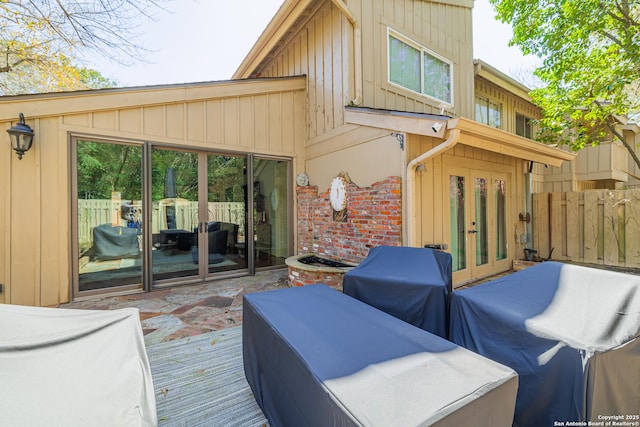 wooden terrace with french doors, a grill, and fence