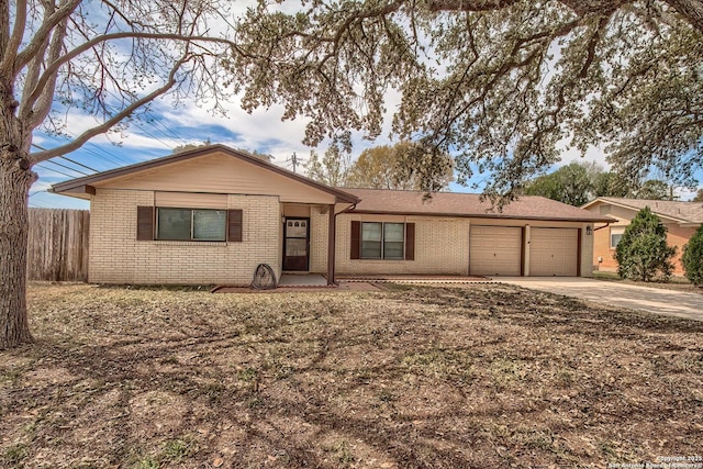 single story home with brick siding, driveway, an attached garage, and fence