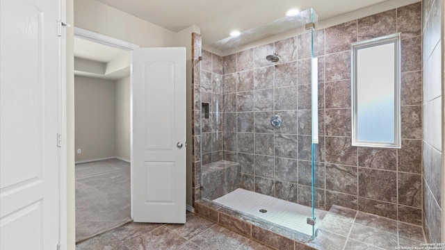 bathroom featuring tile patterned flooring and tiled shower