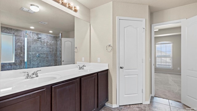 bathroom with double vanity, visible vents, and a sink