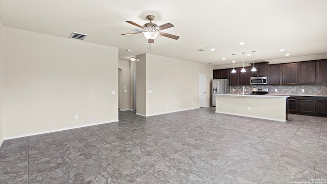 kitchen with tasteful backsplash, visible vents, dark brown cabinetry, open floor plan, and appliances with stainless steel finishes