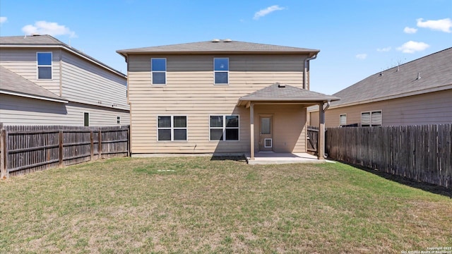 back of house with a fenced backyard, a lawn, and a patio