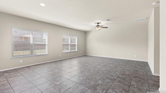 unfurnished room featuring visible vents, baseboards, a textured ceiling, and a ceiling fan