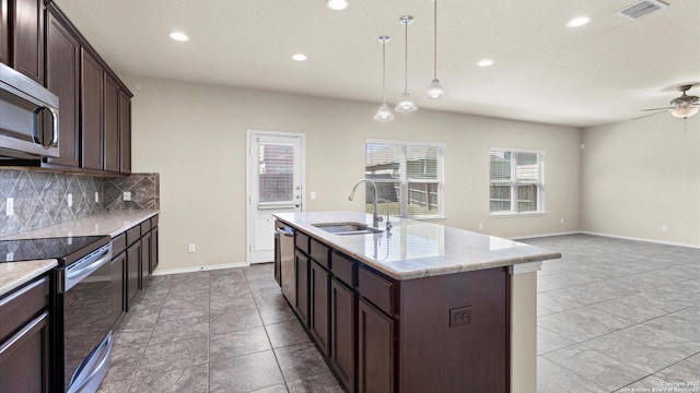 kitchen featuring visible vents, a sink, dark brown cabinets, appliances with stainless steel finishes, and tasteful backsplash