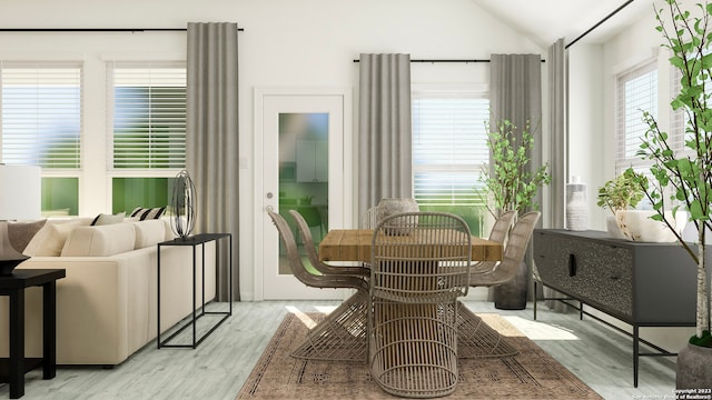 dining room with vaulted ceiling and light wood-style floors