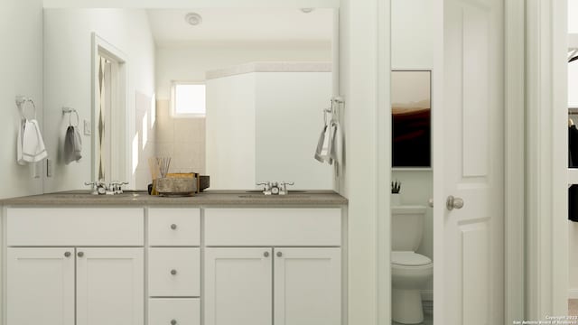 bathroom with a sink, toilet, and double vanity