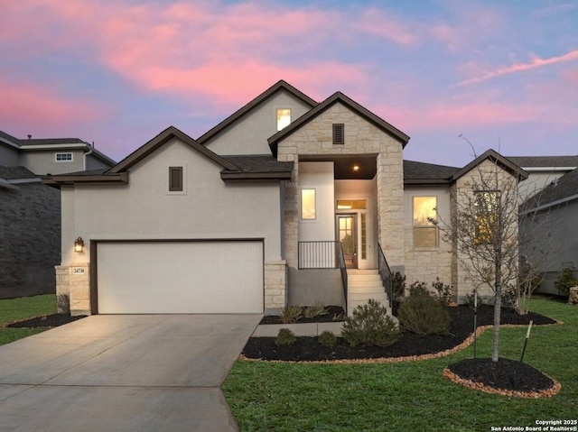 view of front of house featuring stucco siding, a front lawn, driveway, stone siding, and a garage