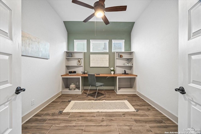 office area with vaulted ceiling, a ceiling fan, baseboards, and wood tiled floor