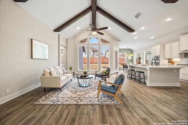 living area with dark wood-style floors, baseboards, visible vents, beam ceiling, and ceiling fan